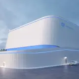 Nowoczesny budynek z logo GE Hitachi, prawdopodobnie elektrownia jądrowa BWRX-300, z niebieskimi akcentami świetlnymi.