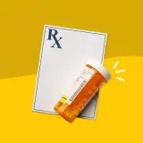 Recept i buteleczka z tabletkami Skudexa 75 mg + 25 mg na żółtym tle.