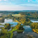 Malowniczy litewski krajobraz z licznymi jeziorami, lasami i zielonymi polami o wschodzie słońca.