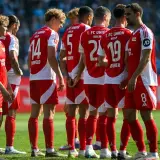 Piłkarze Union Berlin w czerwonych strojach z białymi detalami, w skupieniu przed meczem z Borussią.