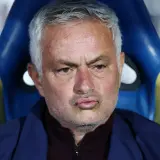Jose Mourinho, były trener Realu Madryt, siedzi na ławce rezerwowych, zamyślony.