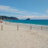 Plage de sable et de galets à Spotorno, Italie. Deux canots de sauvetage rouges sont prêts sur le sable, face à la mer bleue.