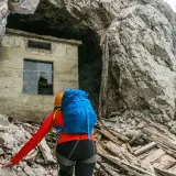 Bergsteigerin nähert sich einer Ruine am Fuße der Zugspitze, die an die Eisenzeit erinnert.