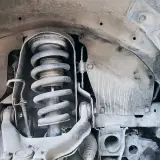Primer plano de un amortiguador de coche, parte esencial para el confort y la seguridad.
