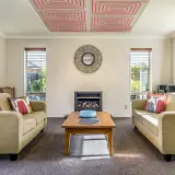 Salón acogedor con sofás, chimenea y un innovador techo radiante que calienta el ambiente.