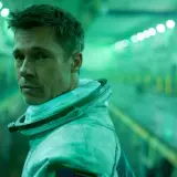 Brad Pitt w skafandrze kosmicznym w filmie Ad Astra, w zielonej poświacie tunelu.