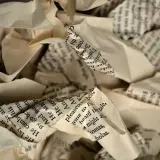 Poskręcane kartki z tekstem, przypominające zniszczony testament z wydziedziczeniem wzór.