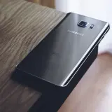 Czarny Samsung leży na drewnianym blacie. Chcesz wiedzieć, jak zresetować Samsung?