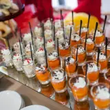 Petits desserts individuels en verrines, certains à la crème et fruits rouges, d'autres à la mousse orange et copeaux de chocolat. Un nom de menu original serait parfait pour ces délices.