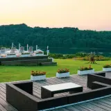 Idealne mazury na weekend: taras z meblami, basen z leżakami i jezioro w tle.