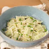 Un plat de ravioli du Dauphiné, généreusement garnis et saupoudrés de ciboulette fraîche et de poivre noir.