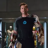 Tony Stark, czyli Iron Man, w swojej zbrojowni, otoczony przez kilka swoich pancerzy.