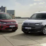 Dwa Volkswageny Caddy 3: czerwony osobowy i biały dostawczy, stoją na tle nowoczesnej architektury i wody.