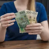 Dłonie trzymają banknoty: 100 zł i dwa 200 zł. To polskie "kosiniakowe" na drobne wydatki.