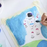 Niño pintando un astronauta en el espacio. Un proyecto de arte en infantil que fomenta la creatividad y la imaginación.