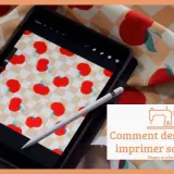 Un dessin sur tissu motif de pommes rouges sur fond à carreaux, visible sur une tablette et un échantillon de tissu.