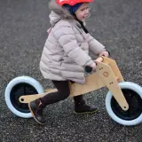 Dziecko na rowerku biegowym, ćwiczy motorykę. To świetny sposób na naukę równowagi i koordynacji.