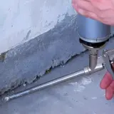 Schaumstoff wird mit einer Pistole in eine Fuge gesprüht. So schließt man Lücken, was ist eine Hohlkehle?