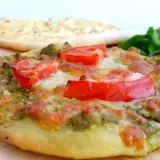 En läcker manakish ost med pesto och tomater, redo att avnjutas.