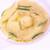 Ravioli z płynnym żółtkiem, ozdobione rozmarynem i przyprawami, danie godne MasterChefa.