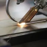 Precyzyjne spawanie laserowe aluminium, tworzące idealne połączenie dwóch elementów. Iskry i jasny łuk świadczą o wysokiej temperaturze procesu.