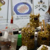 En la feria de la anchoa en Santoña, se exhiben gildas y aceitunas marinadas. Botellas de vino esperan ser servidas.