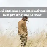Una persona sola in un campo di erba alta, con la scritta "Chi si abbandona alla solitudine, ben presto rimane solo". Mi sento così, non ho amici.
