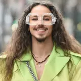 Uśmiechnięty Michał Szpak w limonkowym żakiecie i transparentnych okularach. Czy Michał Szpak jest gejem? To pytanie nurtuje wielu, ale jego styl i pewność siebie mówią same za siebie.