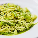 Leckere Trofie-Rezepte mit Pesto und grünen Bohnen auf einem weißen Teller.
