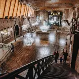Rodzina schodzi schodami do podziemnej kaplicy w kopalni soli „wieliczka” opinie. Kryształowe żyrandole oświetlają solne rzeźby.