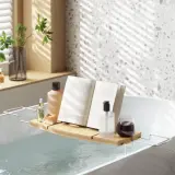 Relaks w wannie jak w spa: książka, kosmetyki i napój na tacce. Idealne miejsce na odprężenie.