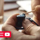 Pokazano, jak wyczyścić słuchawki douszne za pomocą wykałaczki. Dbanie o czystość słuchawek zapewnia lepszą jakość dźwięku.