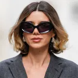 Mujer con gafas de sol y un moderno balayage pelo corto en tonos miel y castaño.