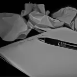 Carta accartocciata e penna su foglio bianco. La frase "Mein lieber Schatz" è scritta a mano.