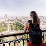 Kobieta z plecakiem podziwia panoramę Paryża. To idealny czwartek po francusku, pełen słońca i widoków.