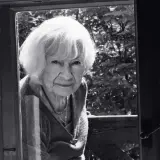 Portret starszej kobiety z siwymi włosami, patrzącej przez okno. Może to być inspiracja do filmów Doroty Kędzierzawskiej.