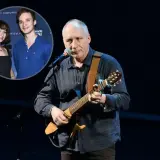 Kuba Sienkiewicz gra na gitarze, a w tle widać jego dzieci.