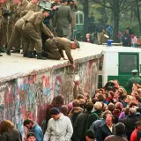 Menschen feiern die Wiedervereinigung Deutschlands am Berliner Mauer. Soldaten helfen Menschen über die Mauer. Eine Zusammenfassung der Freude und des Wandels.