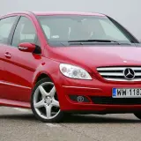 Czerwony Mercedes W245 na drodze, z widocznym grillem i reflektorami.