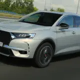 Srebrny DS 7 Crossback E-Tense pędzi autostradą, jego elegancka linia podkreślona przez dynamiczne światła.