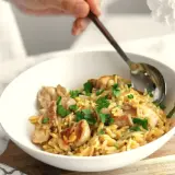 Miseczka z kurczakiem i makaronem orzo, posypana natką pietruszki. Idealne na proste przepisy na obiad.