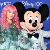 Dziewczyna z różowymi włosami i Myszka Miki pozdrawiają na tle napisu "Disney 100". Może to zapowiedź nowych piosenek Disneya?