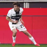 Piłkarz Parma Calcio 1913 z numerem 25 na koszulce w białym stroju z czarnymi elementami, gotowy do akcji na boisku.