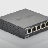 Un petit switch D-Link DGS-105 noir, avec cinq ports Ethernet, prêt à connecter vos appareils.