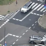 Skrzyżowanie równorzędne znak. Dwa samochody zbliżają się do przejść dla pieszych.