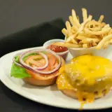 Pyszny burger z serem, frytki i ketchup. Czym się różni hamburger od burgera? Ten wygląda na pyszny!