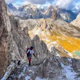 Bergsteiger auf dem Paternkofel Klettersteig, umgeben von majestätischen Dolomiten. Ein Abenteuer mit atemberaubender Aussicht.