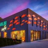 Oceanarium w Międzyzdrojach, z neonowym napisem i pomarańczowymi rybkami na fasadzie, to świetne miejsce na międzyzdrojskie atrakcje dla dzieci.