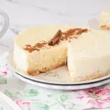 Deliciosa tarta de arroz cremosa, decorada con canela en rama y espolvoreada. Un trozo ya servido.