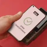 Zbliżeniowa płatność telefonem przez blik. Na ekranie telefonu widnieje potwierdzenie transakcji 12 PLN.